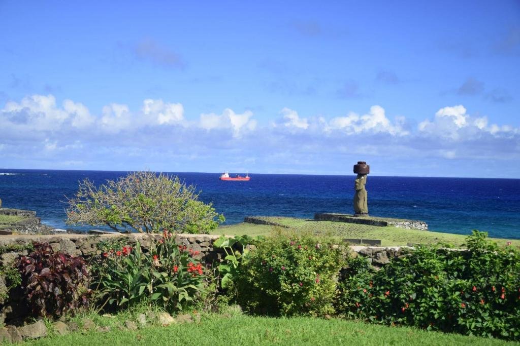 Vista al mar y a un moái desde el jardín del lodge