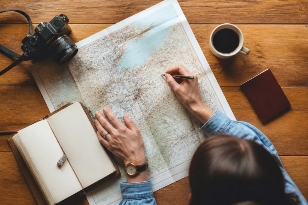 Viajera planificando su itinerario personalizado con un mapa y una libreta Viajera planificando su itinerario personalizado con un mapa y una libreta